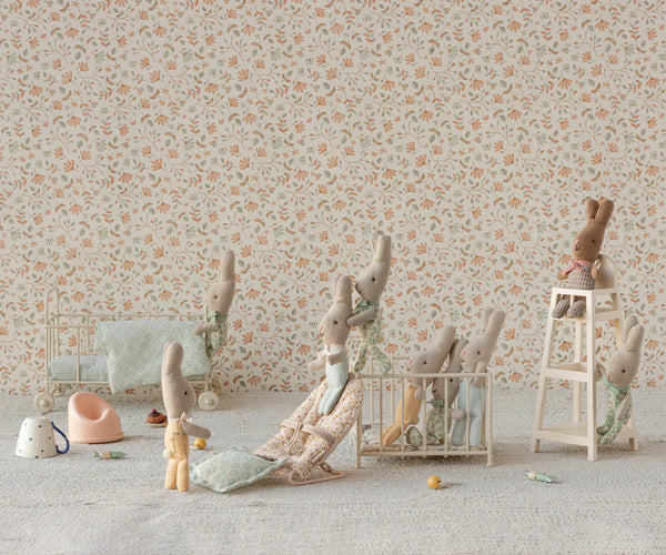Children's room with floral wallpaper and stuffed animal toys on a light-colored floor.
