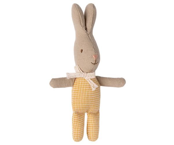 Stuffed rabbit toy with beige body and yellow checkered onesie on a white background