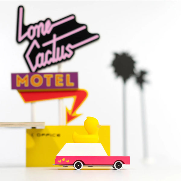 Vintage-style neon sign for 'Lone Cactus Motel' with a palm tree silhouette on a white background.