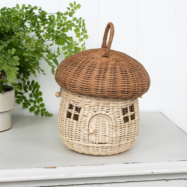 Wicker basket designed like a house with a lid on a white surface.