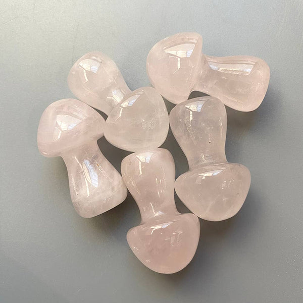 Set of rose quartz mushroom-shaped stones on a light grey background