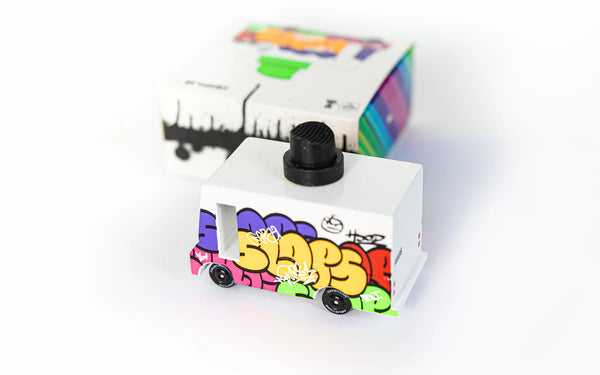 Small white toy truck with colorful graffiti-style text on a white background