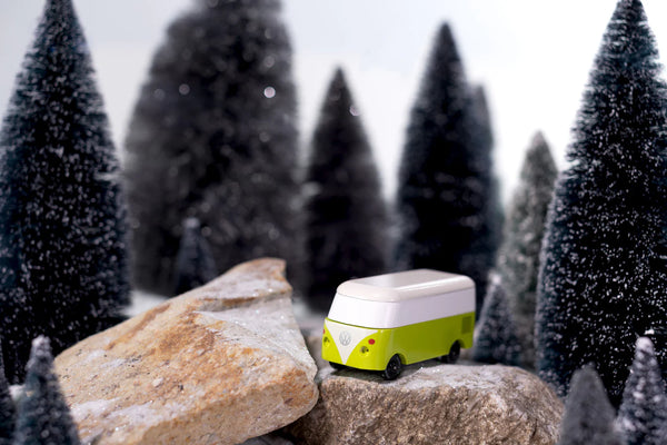 Toy van on a rock with snowy trees in the background