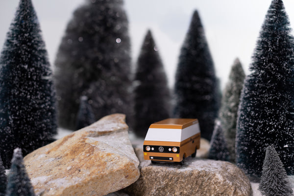 Model van on rocks with snowy trees in the background