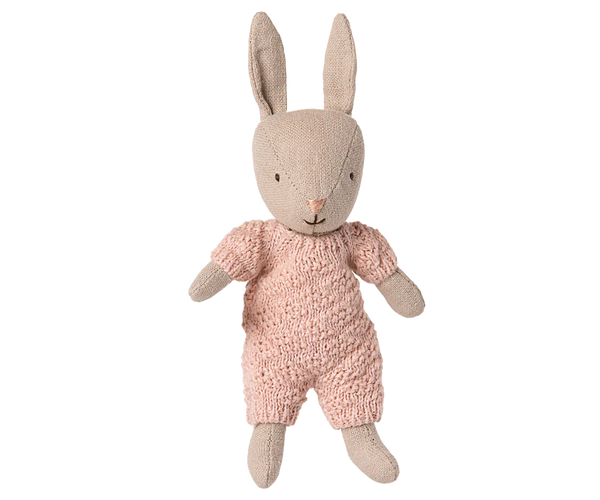 Stuffed rabbit toy wearing a pink outfit on a white background