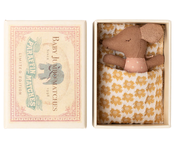 Small brown mouse in a decorative box with a floral patterned blanket