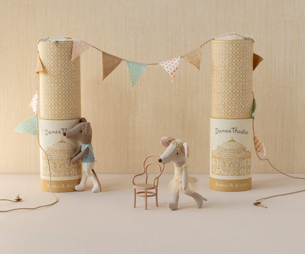 Two stuffed animal toys with decorative boxes and a banner on a neutral background