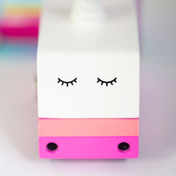 Colorful toy truck with a unicorn design on a blurred background