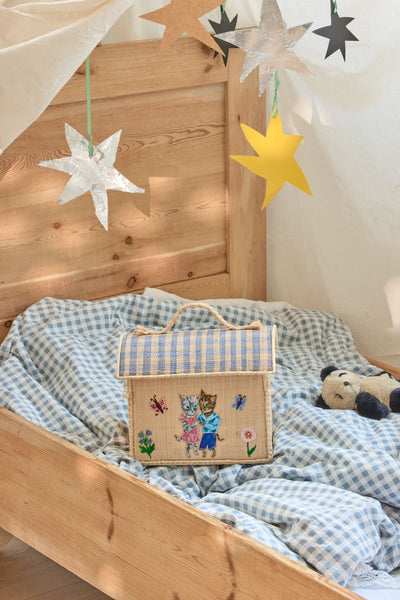 Angled view of Nathalie Lété Theme Kids Raffia Bag on a child's bed