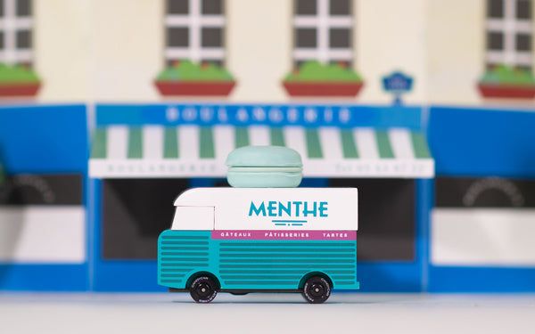 Model van with 'Menthe' branding in front of a blurred storefront