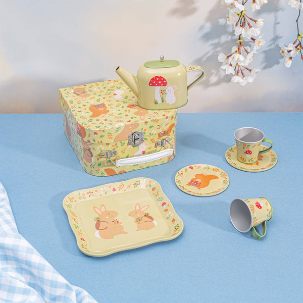 Children's tea set with teapot, cups, and tray on a blue surface.