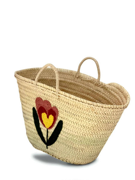 Woven basket with a floral design on a white background