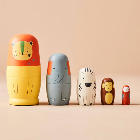 Set of colourful animal-themed nesting dolls on a beige background