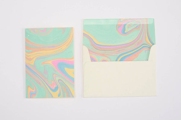 Two colorful marbled greeting cards and an envelope on a white background