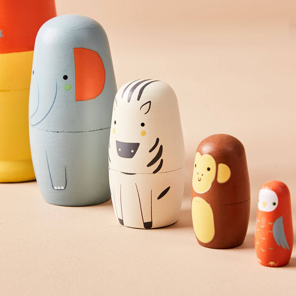Set of colourful animal-themed nesting dolls on a beige background