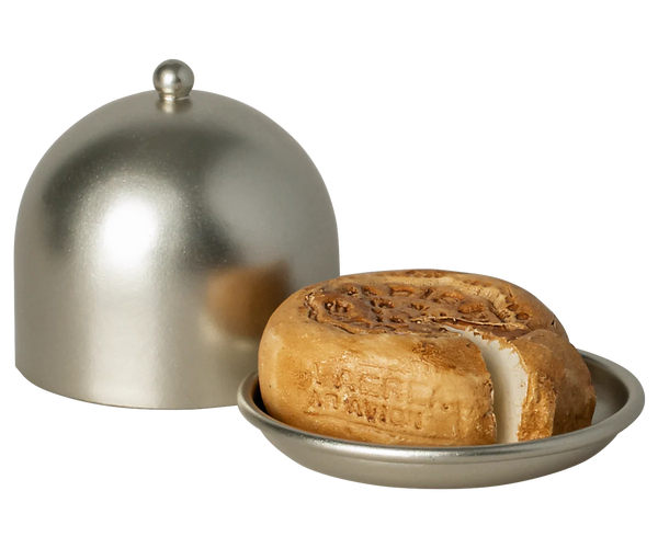 Toy cheese wheel with a dome cover on a white background