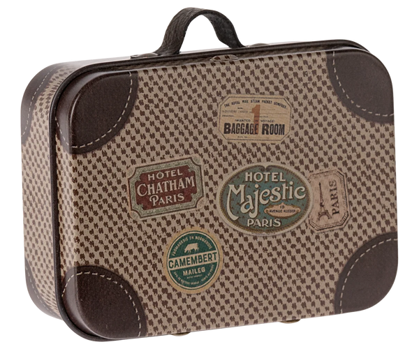 A vintage-style miniature suitcase with a brown and beige houndstooth pattern, faux leather trim, and multiple colourful travel ticket stickers on the front.
