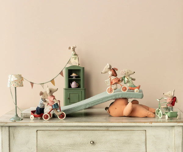 Toy mice with accessories on a wooden surface with a neutral background