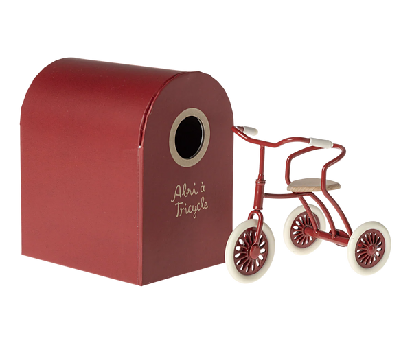 Red and white tricycle toy with a red storage shed on a white background