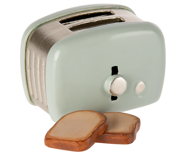Small mint green toaster with two slices of bread on a white background