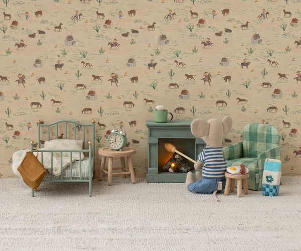Miniature room setup with furniture and a mouse character in front of a fireplace, against a wallpapered wall.