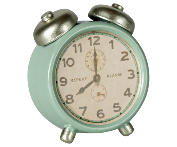 Vintage-style alarm clock with a light green casing and silver bells on a white background.