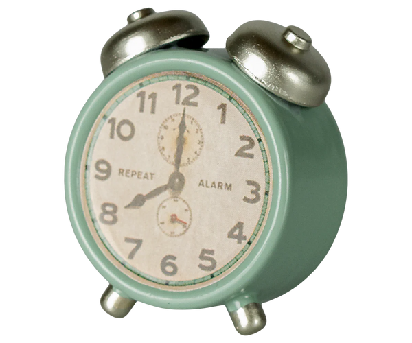 Vintage-style alarm clock with a mint green body and silver bells on a white background