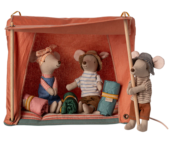 Three toy mice in a camping scene with a tent and camping gear on a white background