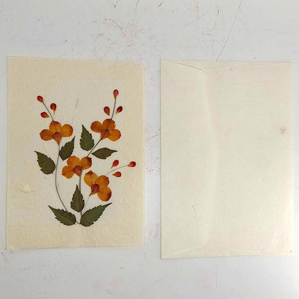 Floral design on a beige card with a plain envelope on a plain background