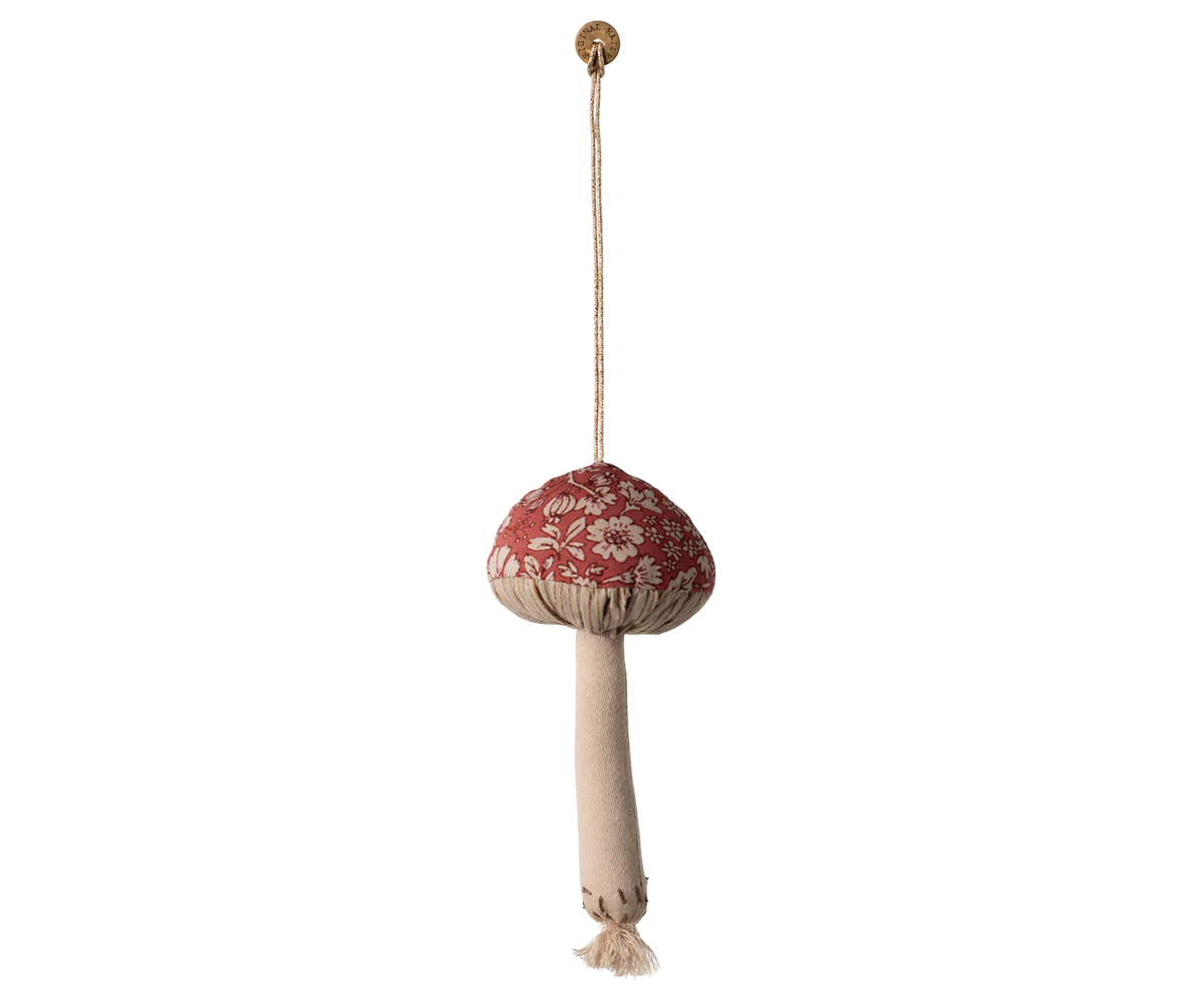 Decorative hanging mushroom with floral pattern and beige tassel on a white background