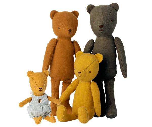 Four teddy bears in different colours on a white background
