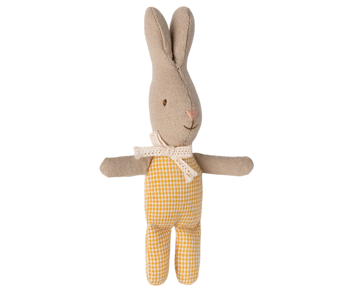 Stuffed rabbit toy with beige body and yellow checkered onesie on a white background