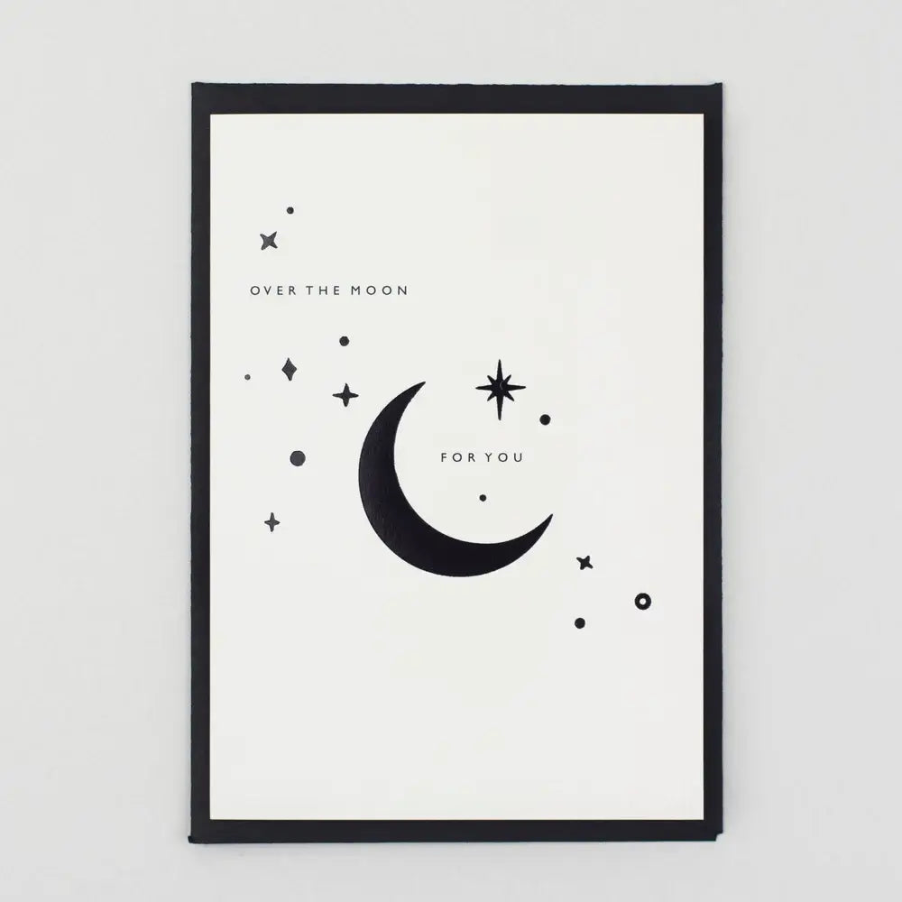 Greeting card with a moon and star design against a dark envelope on a white background