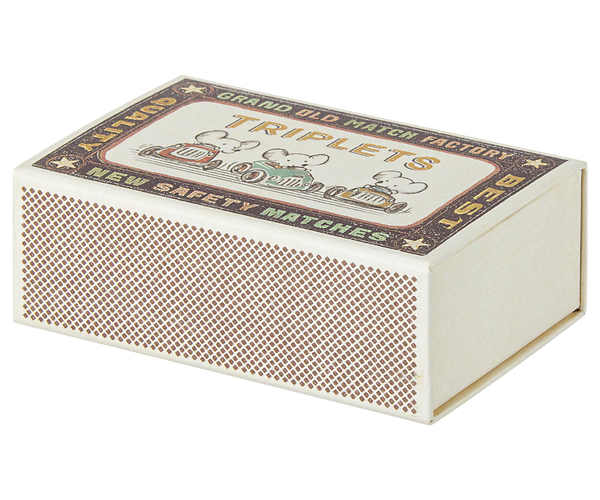 Vintage-style matchbox with decorative label on a white background