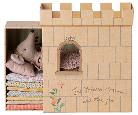 Cardboard castle toy with plush toys and fabric inside, branded 'The Princess Mouse and the Pea'.