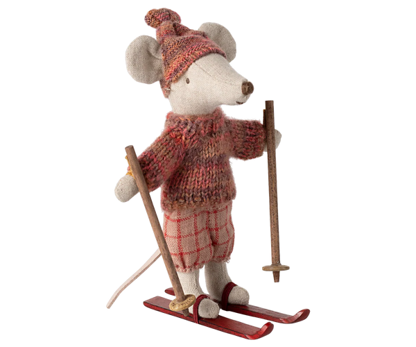 Stuffed toy mouse in winter attire with skis and ski poles on a white background