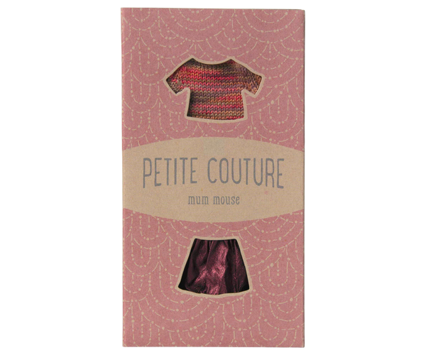 Package of 'Petite Couture' with a small dress on a pink background