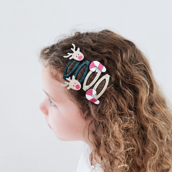 Child with decorative hair clips on a plain background