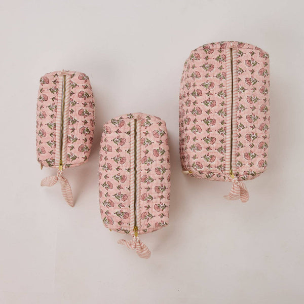 Three pink floral-patterned pouches on a white background