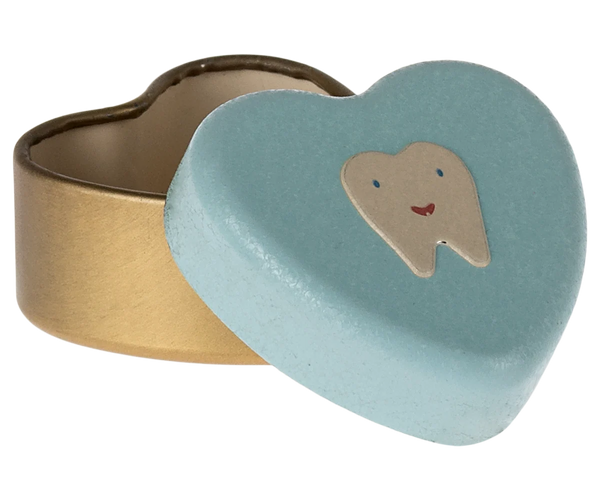 A heart-shaped ring box with a brushed gold metal base and a mint lid featuring a smiling tooth illustration.