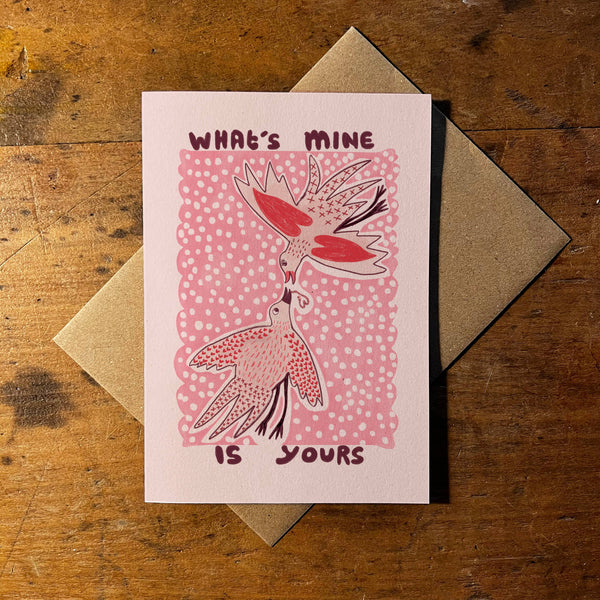 Greeting card with birds and text 'What's mine is yours' on a wooden surface