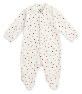 White baby onesie with red star and dot pattern on a white background