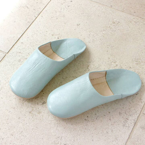 Pair of light blue slippers on a light tiled floor