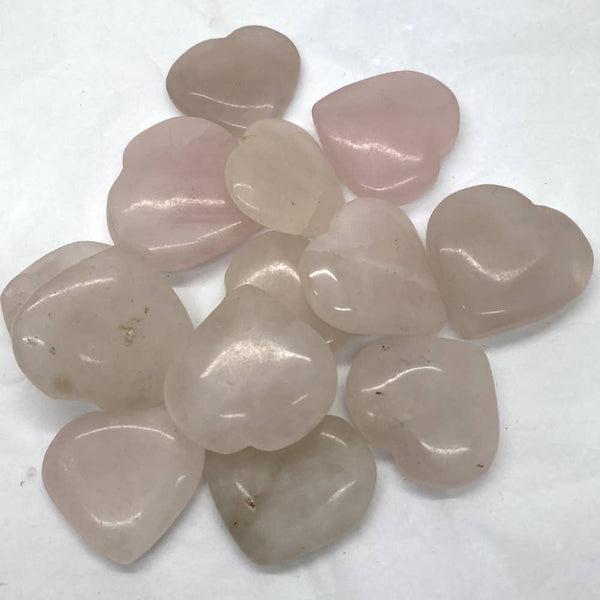 Heart-shaped rose quartz stones on a white background