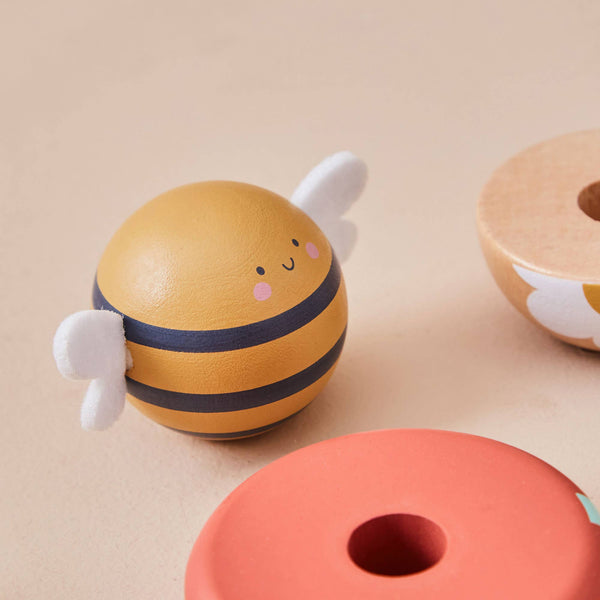 Toy bee with striped body and white wings on a beige background
