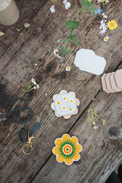 Floral shaped mini flower presses on a wooden surface with scissors and flowers.
