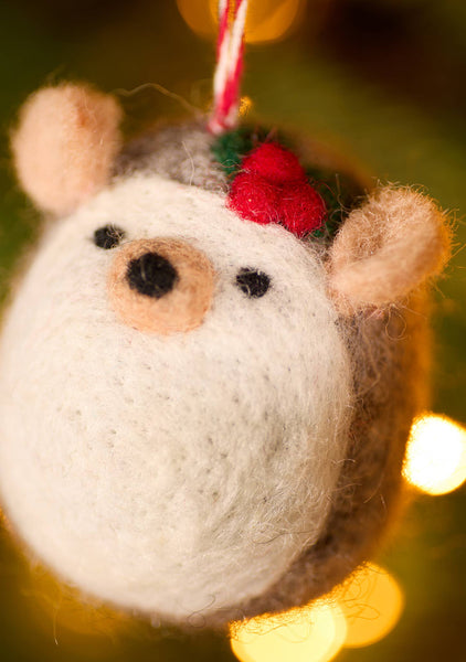 Felted hedgehog ornament against a blurred light background