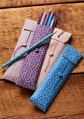 Packs of 5 pencils with floral patterns on a wooden surface