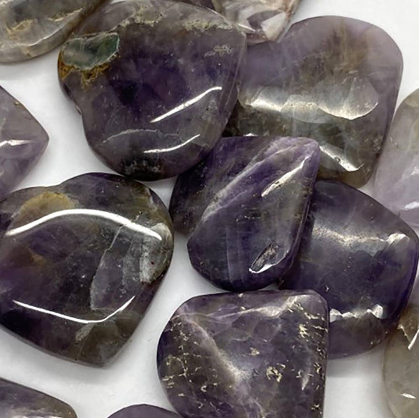 Close-up of purple amethyst crystals on a white background