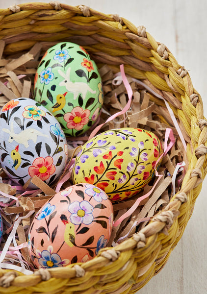 Decorative Easter eggs with floral patterns in a woven basket.